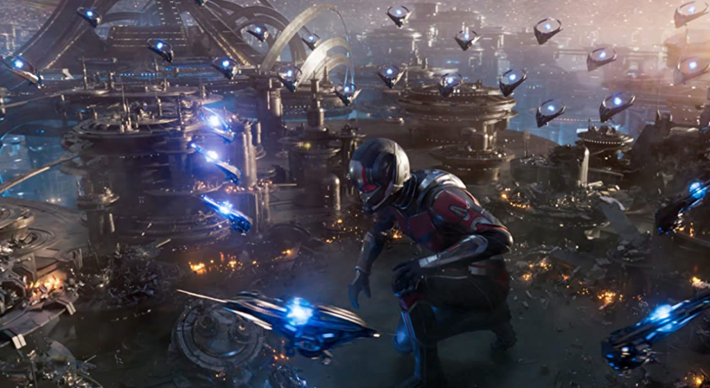 Giant Ant-man kneels down as ships attack him.  